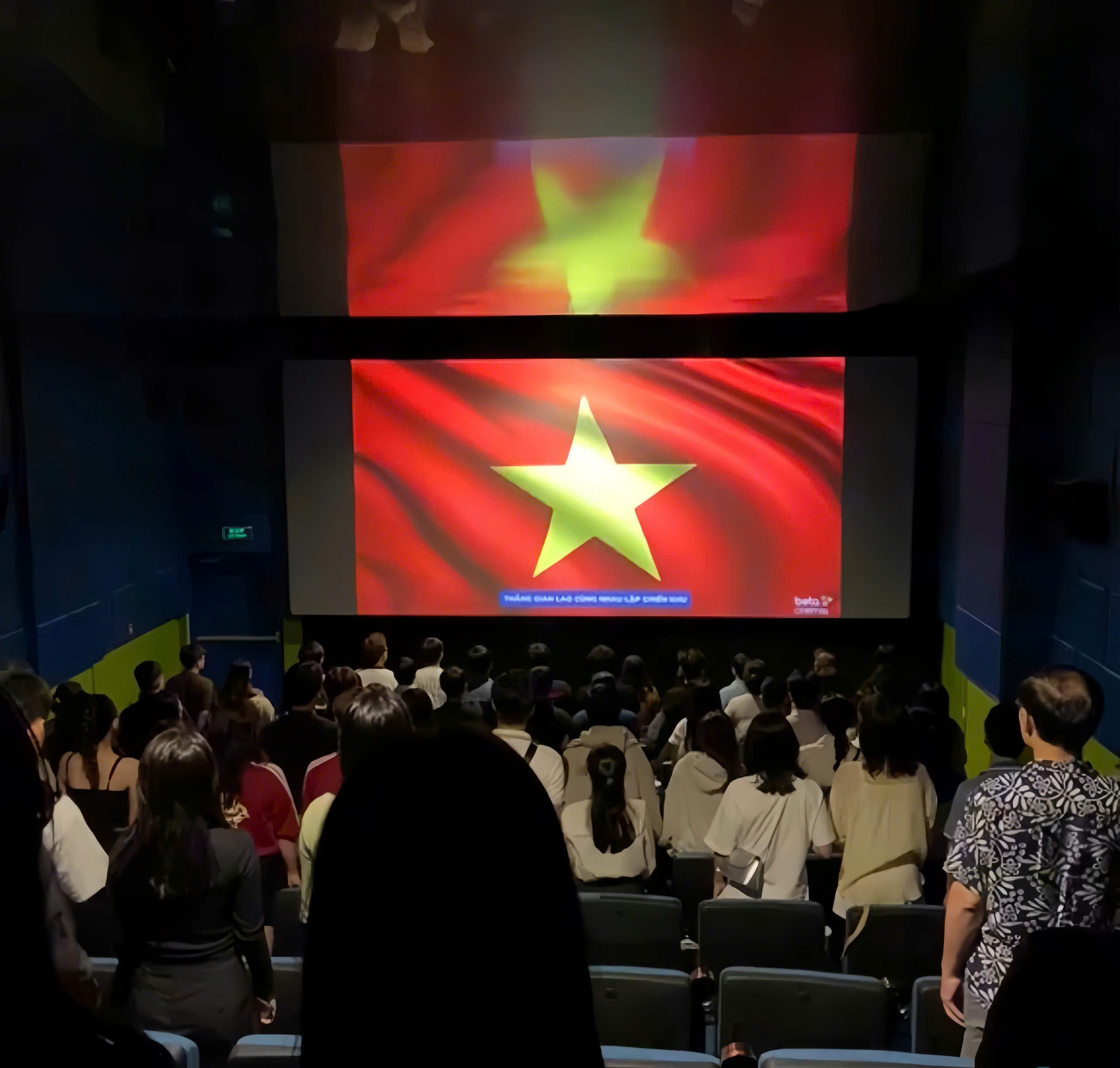 Cảnh mọi người chào cờ trong rạp phim Mưa Đỏ